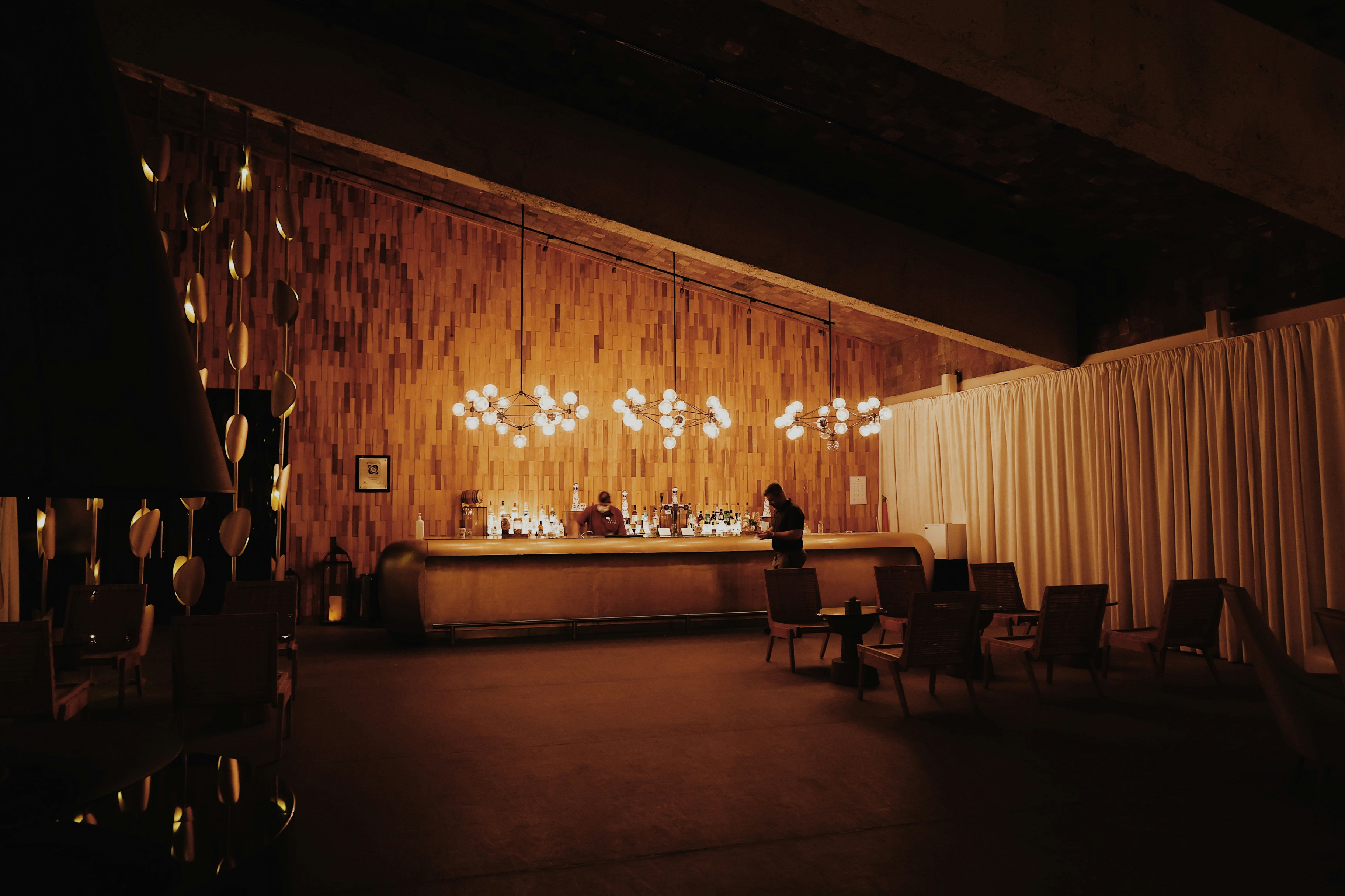 A dimly lit room with chairs and a bar