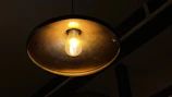 A minimalist round ceiling light casting a soft, warm glow in a cozy living room.