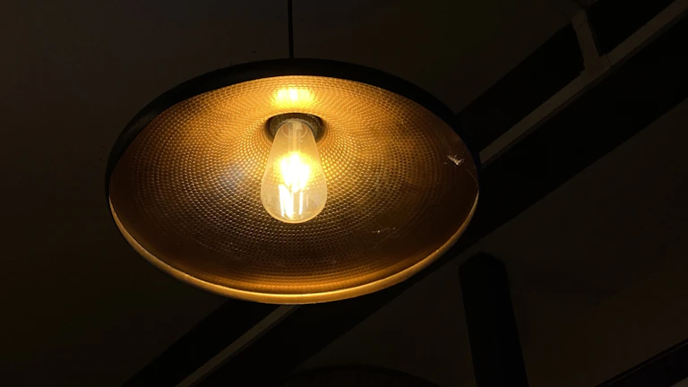 A minimalist round ceiling light casting a soft, warm glow in a cozy living room.