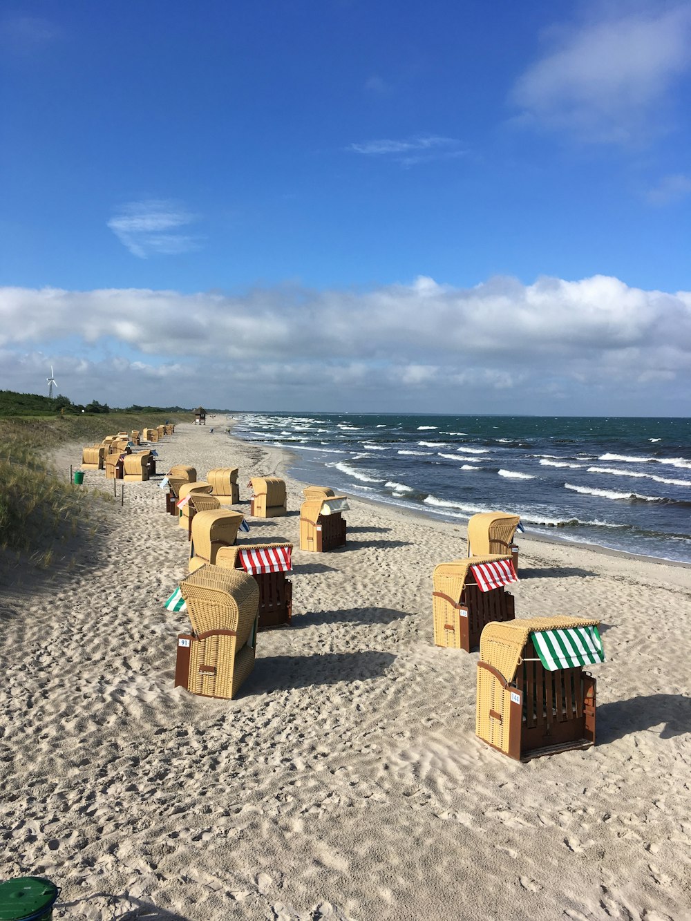 a row of beach chairs sitting on top of a sandy beach