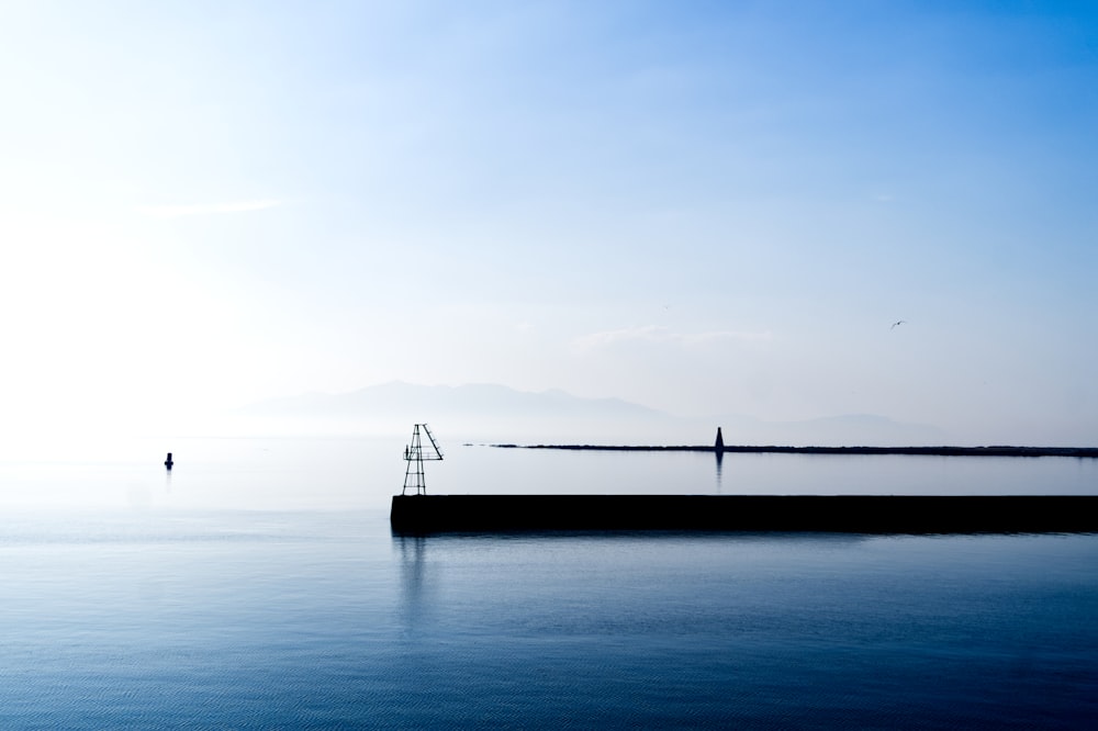 a large body of water sitting under a blue sky