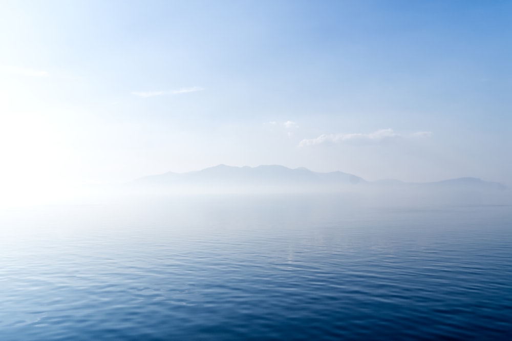 a large body of water with mountains in the background