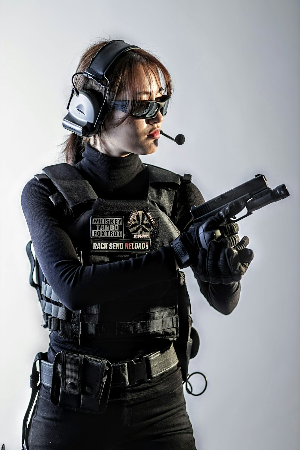 a woman in a black outfit holding a gun