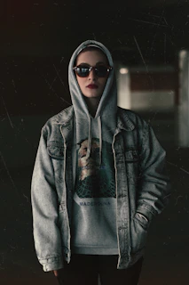 a woman wearing a hoodie and sunglasses