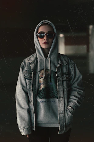 a woman wearing a hoodie and sunglasses
