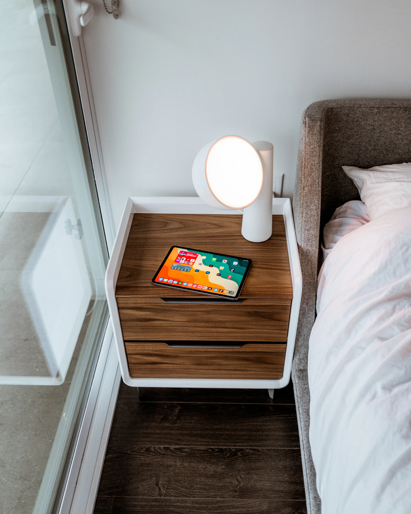 Smartphone liegt auf einem Nachttisch außerhalb des Bettes