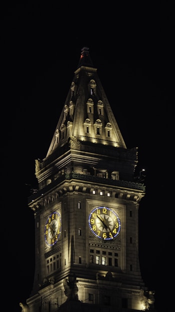 a large clock tower lit up at night