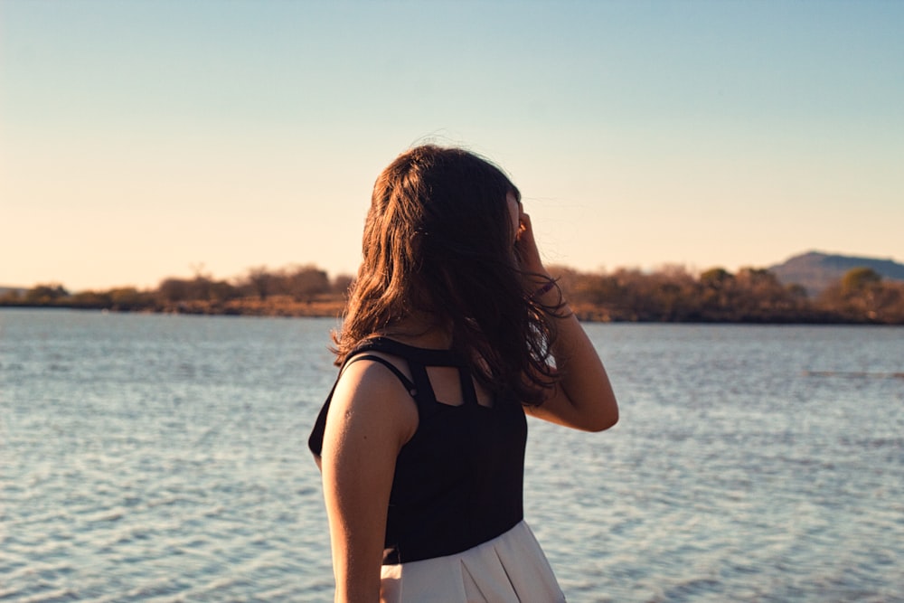 a woman standing by a body of water