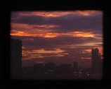 Wide-angle shot of an urban skyline at dusk with dramatic shadows.