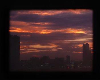Downtown Los Angeles skyline at dusk with dark purple hues.