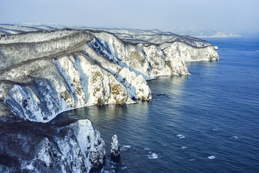 a large body of water surrounded by snow covered mountains