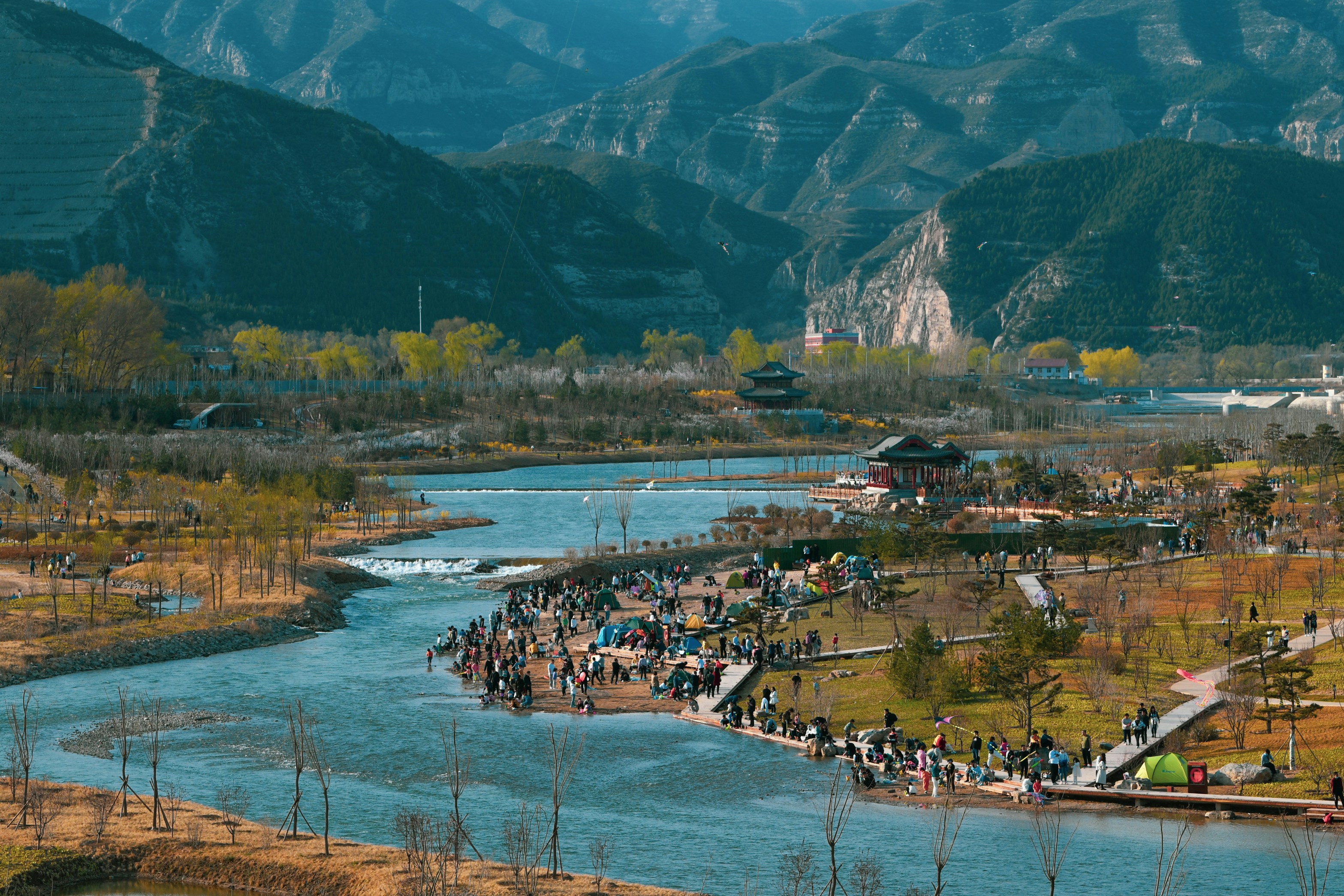 a group of people standing next to a river