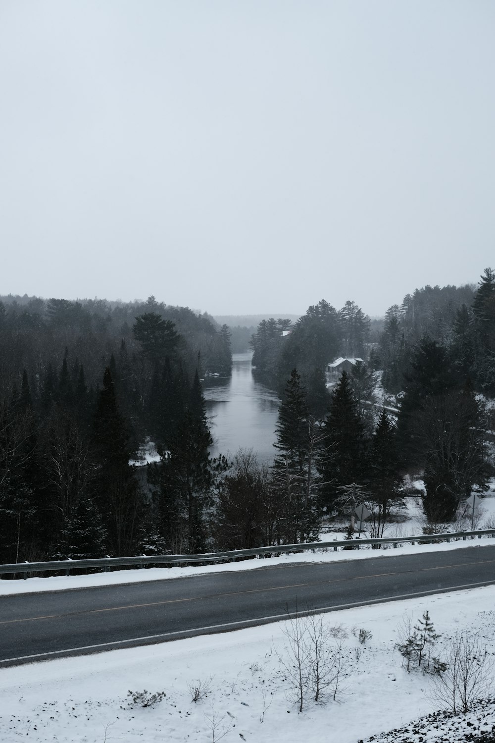 a snow covered road with a river in the distance