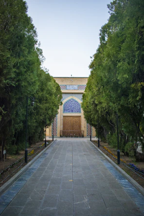 a walkway leading to a building surrounded by trees