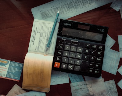 a calculator and invoice log on top of a wooden table