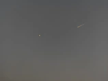 A dynamic news ticker overlaying a starfield background with science headlines.