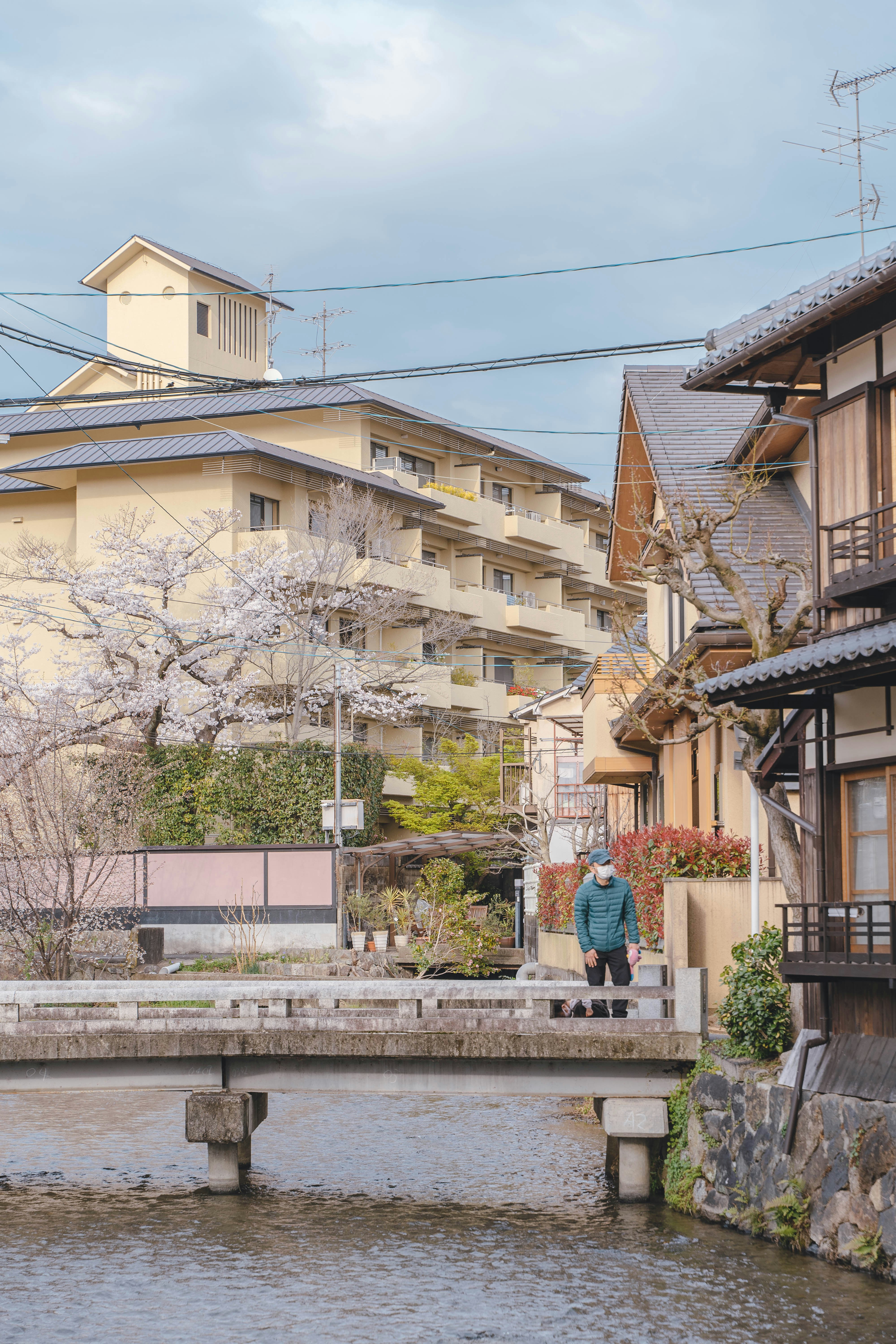 a man walking across a bridge over a body of water