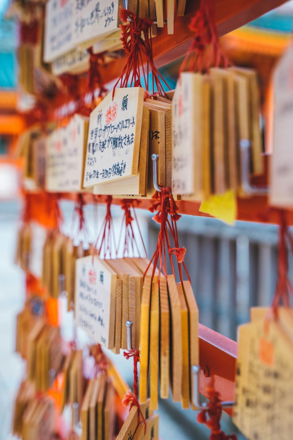 a bunch of tags hanging from a wooden pole