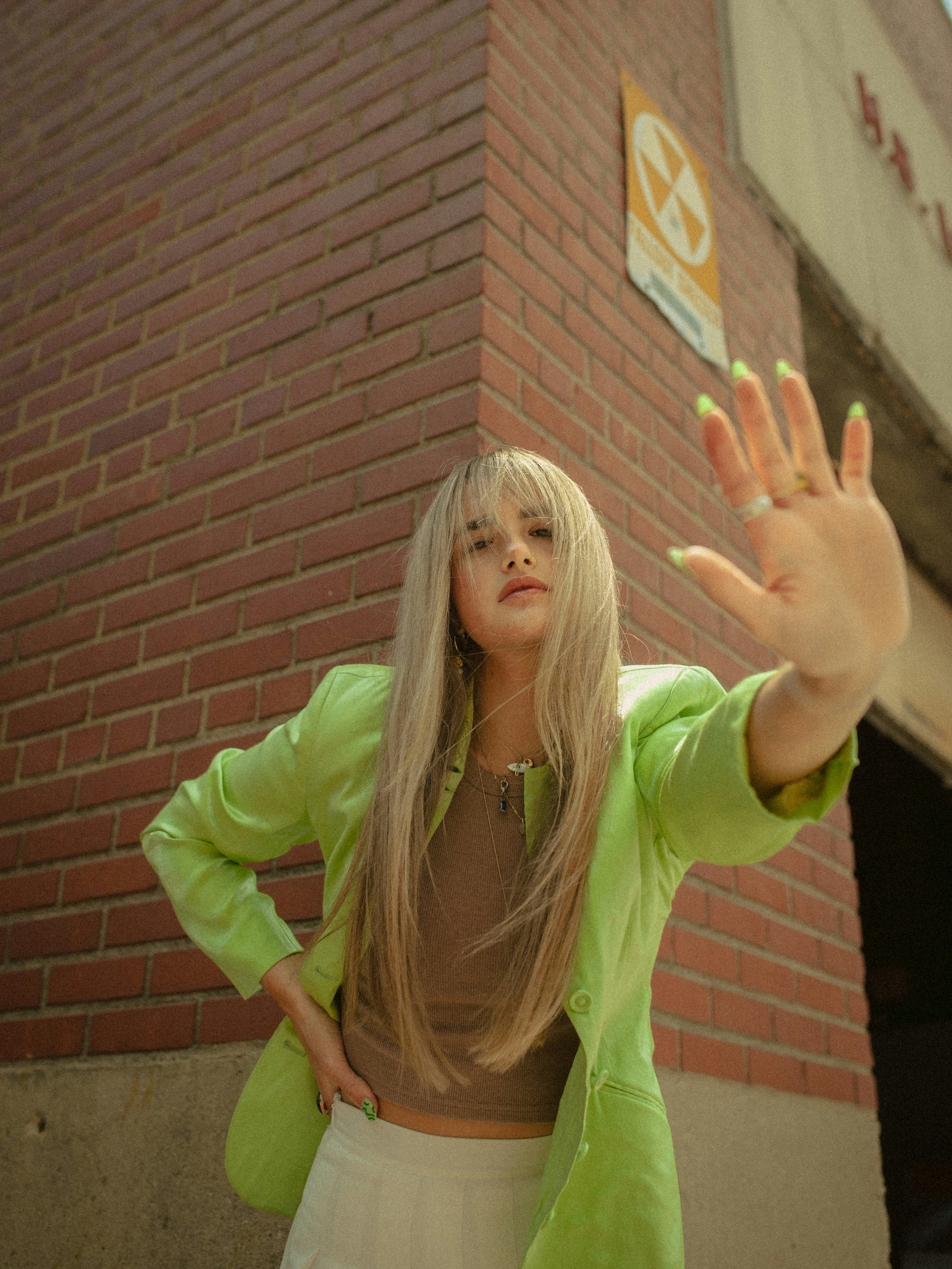 a woman standing in front of a brick building