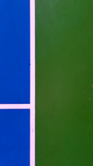 Close-up of vibrant green acrylic pickleball court with freshly painted lines.