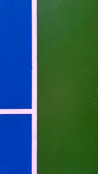 Close-up of vibrant green acrylic pickleball court with freshly painted lines.