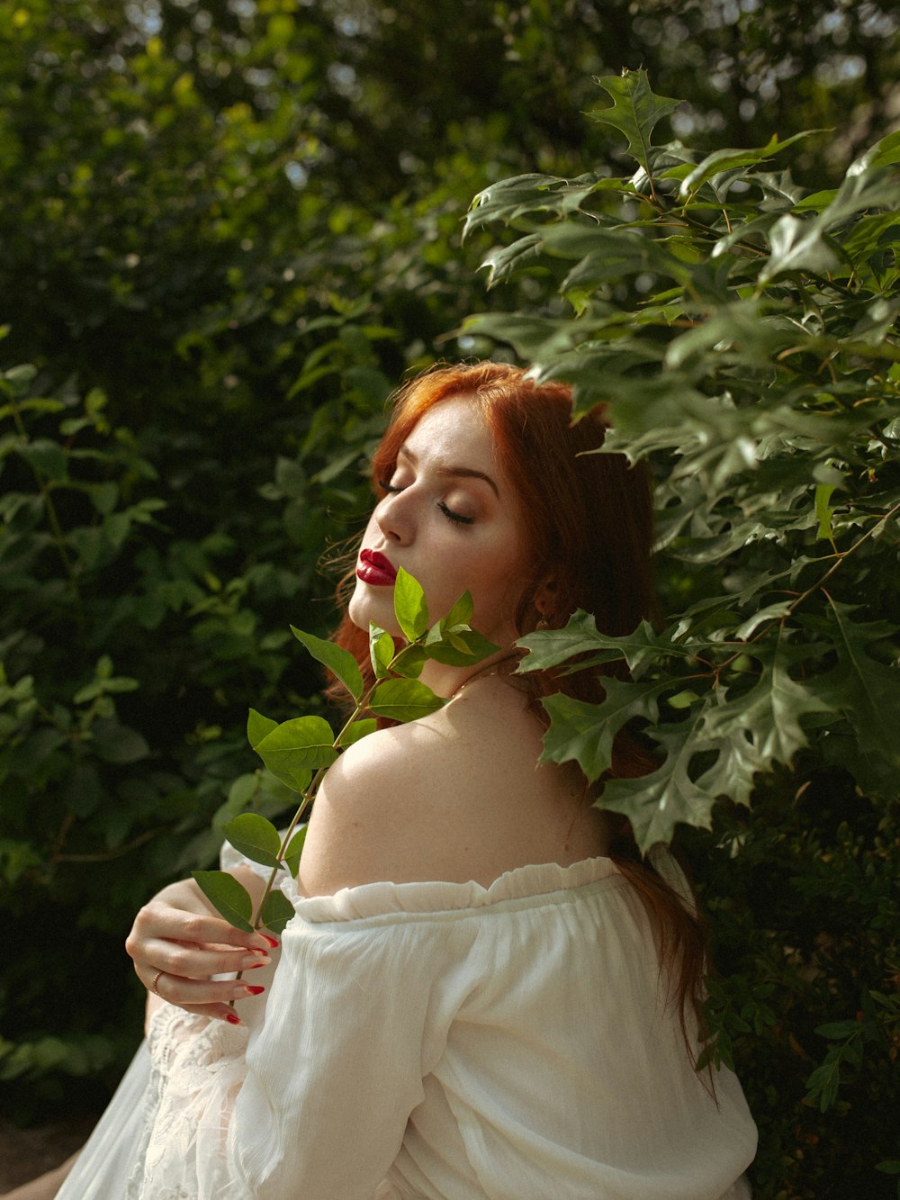 a woman in a white dress holding a green leaf