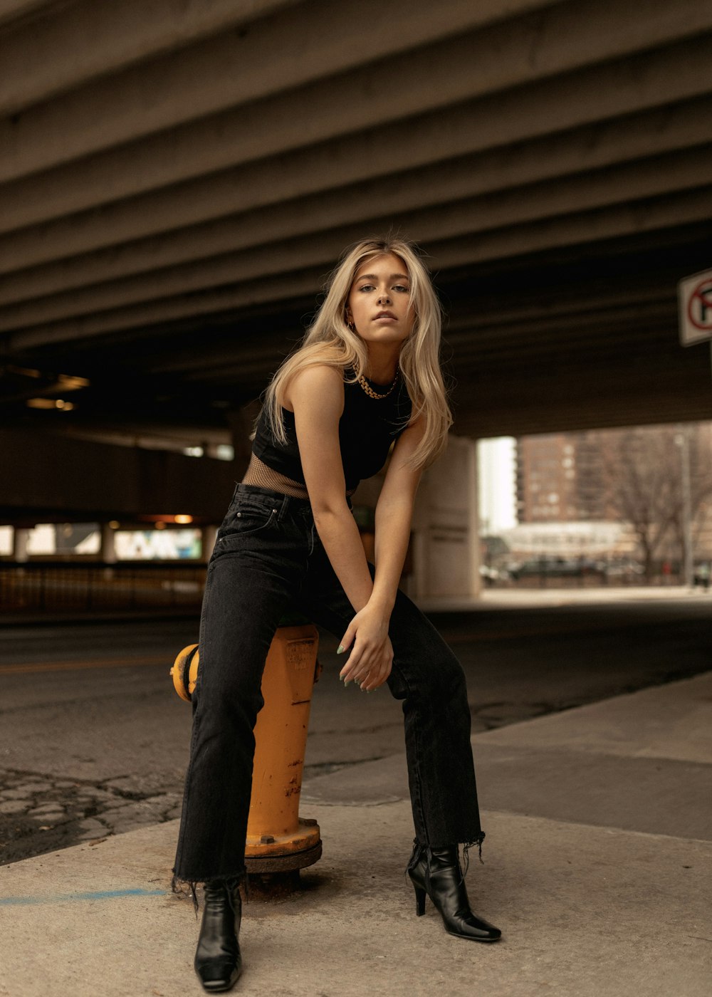 a woman sitting on top of a fire hydrant