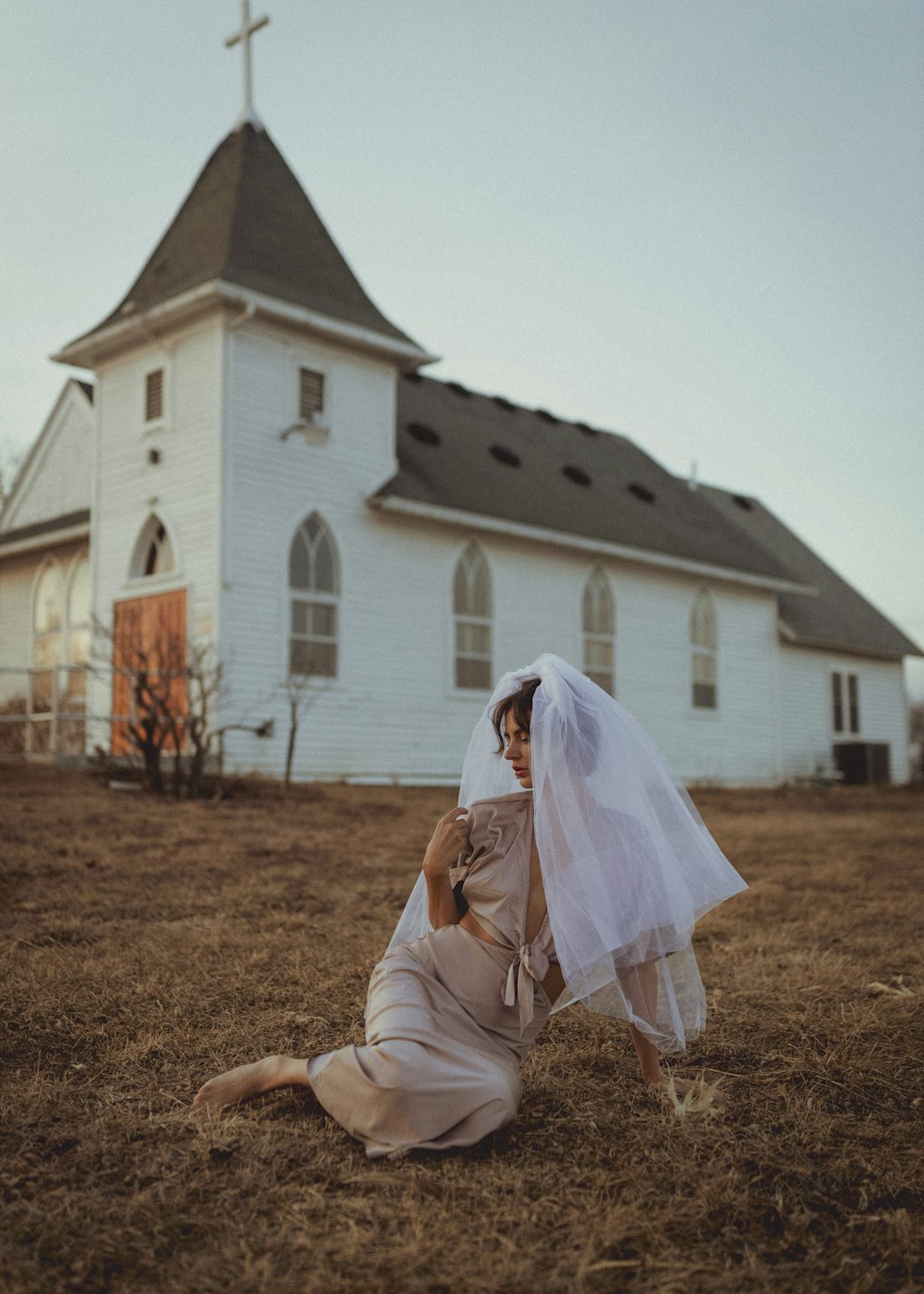 a woman laying on the ground in front of a church