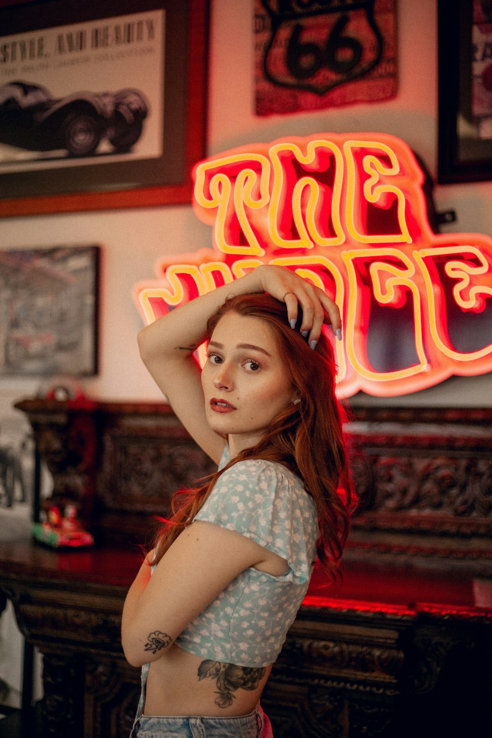 a woman standing in front of a neon sign