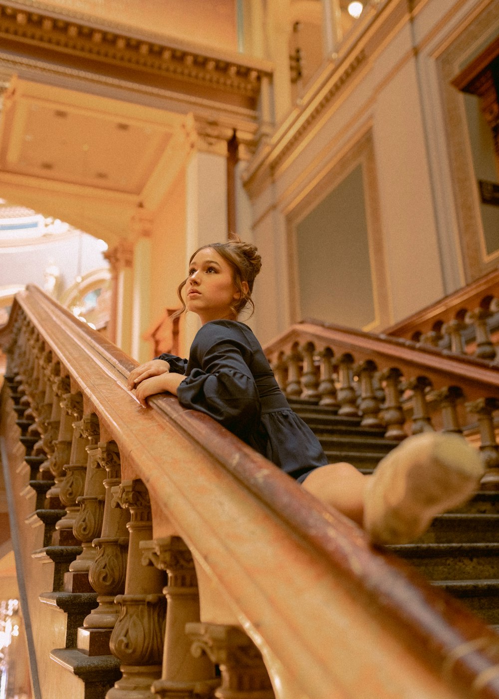 a woman sitting on a railing in a building