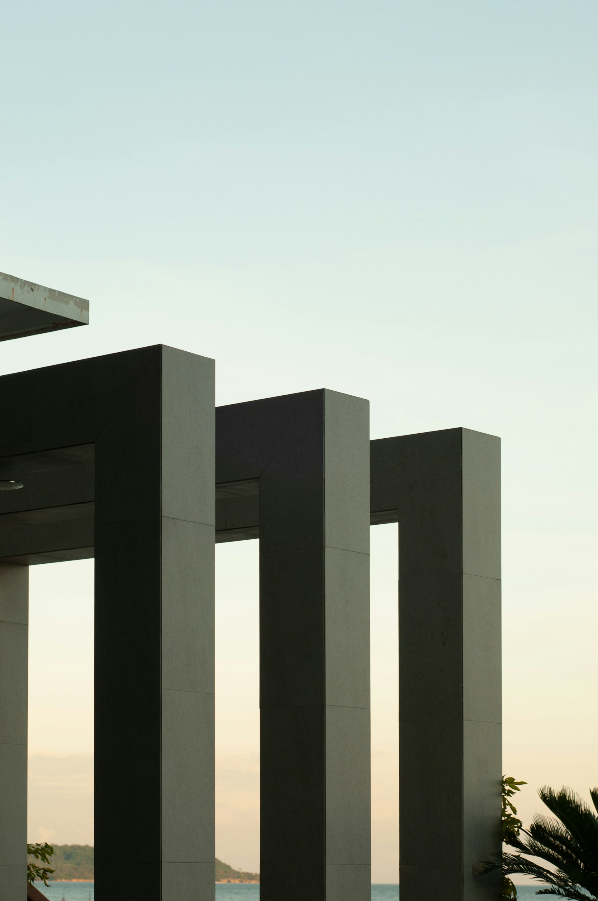 a couple of tall pillars sitting next to a body of water