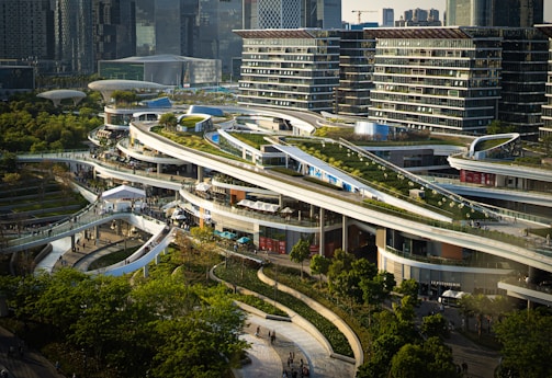 A vibrant commercial complex bustling with people and greenery integrated into the architecture.