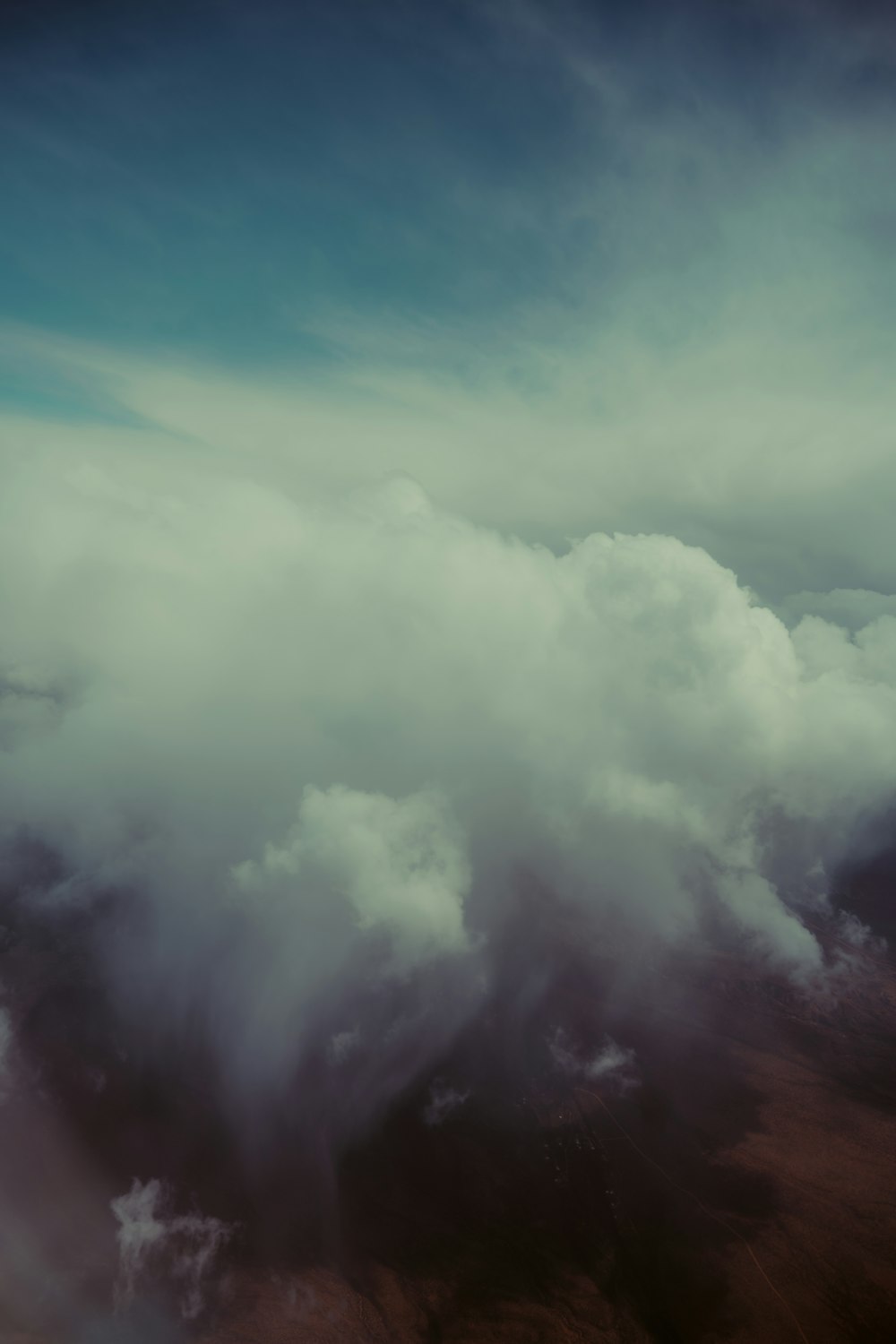 an airplane flying through a cloudy blue sky