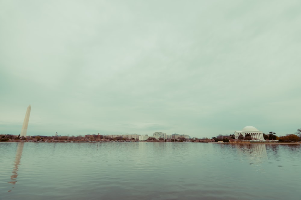 a large body of water with a white building in the background