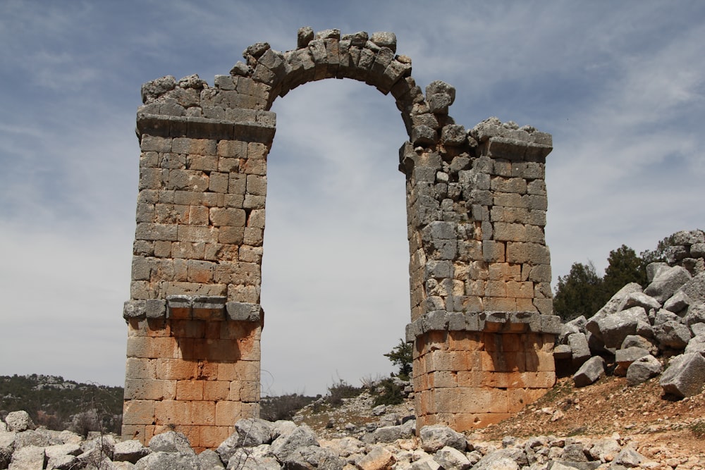 two stone archways in a rocky area under a blue sky