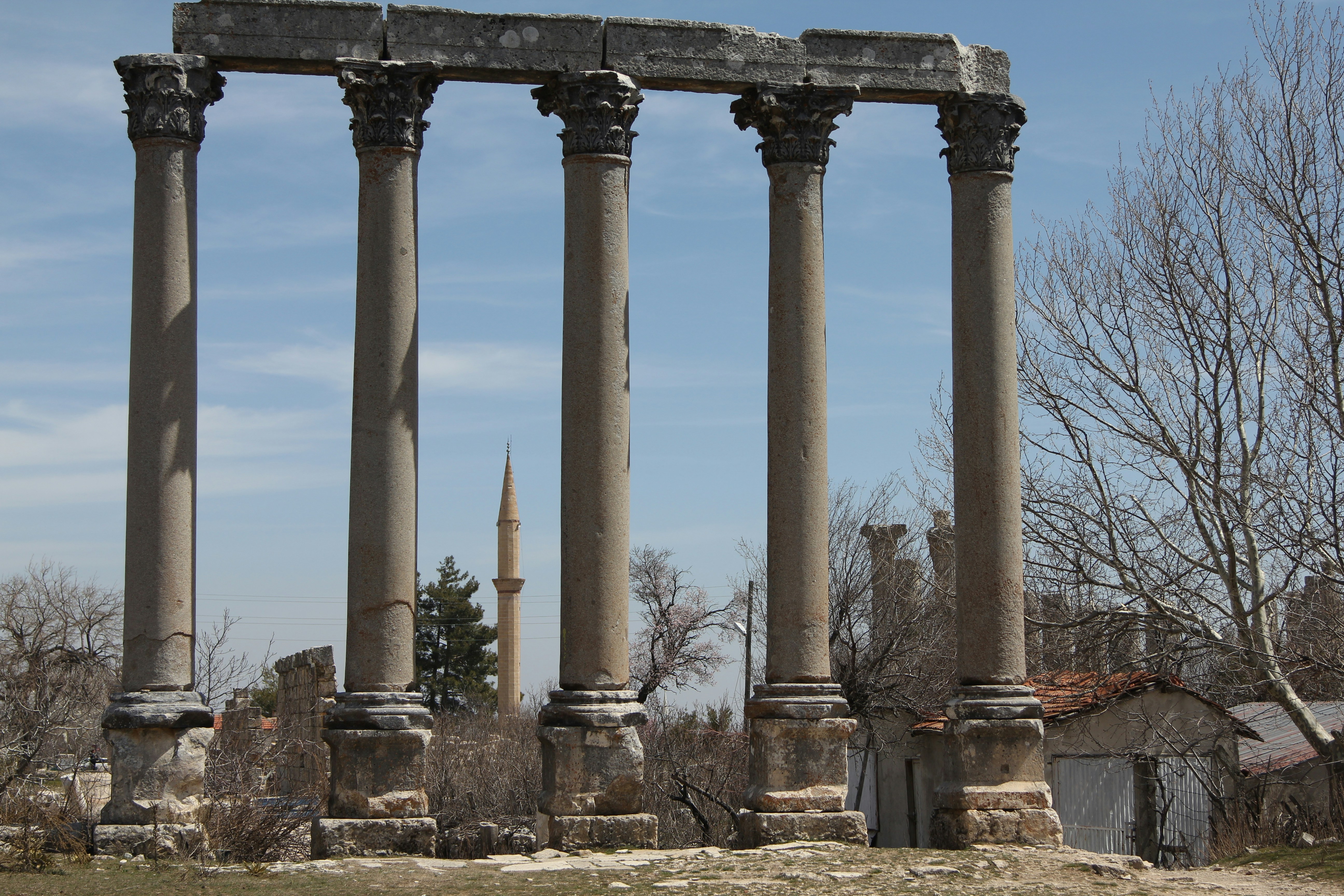 a row of pillars with a building in the background, The Ancient City of Olba in Turkey