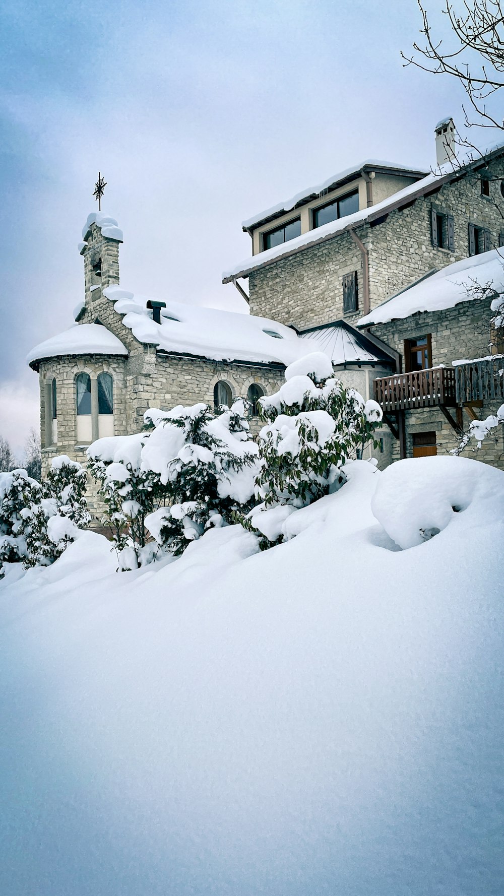 Una casa coperta di neve con una torre dell'orologio sullo sfondo