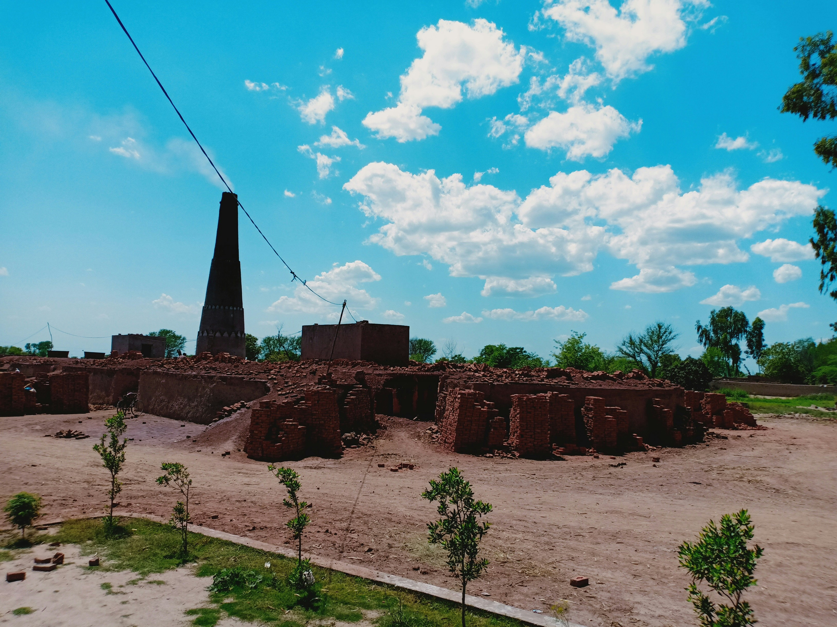 A dirt field with a tower in the background