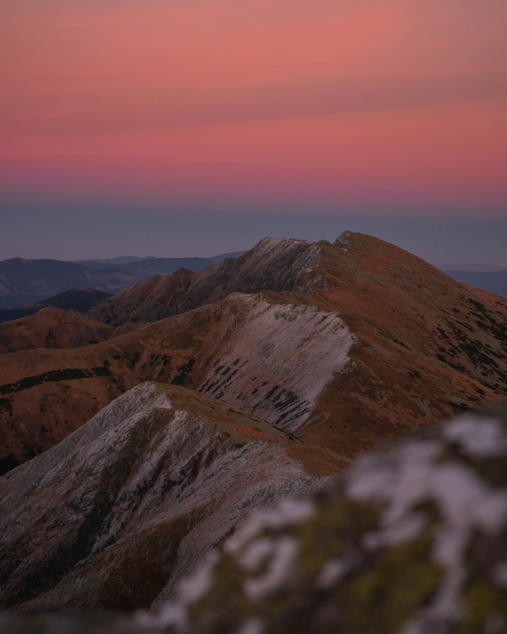 a view of the mountains at sunset from the top of a mountain