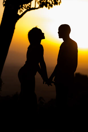 A vibrant sunset backdrop with the couple holding hands.