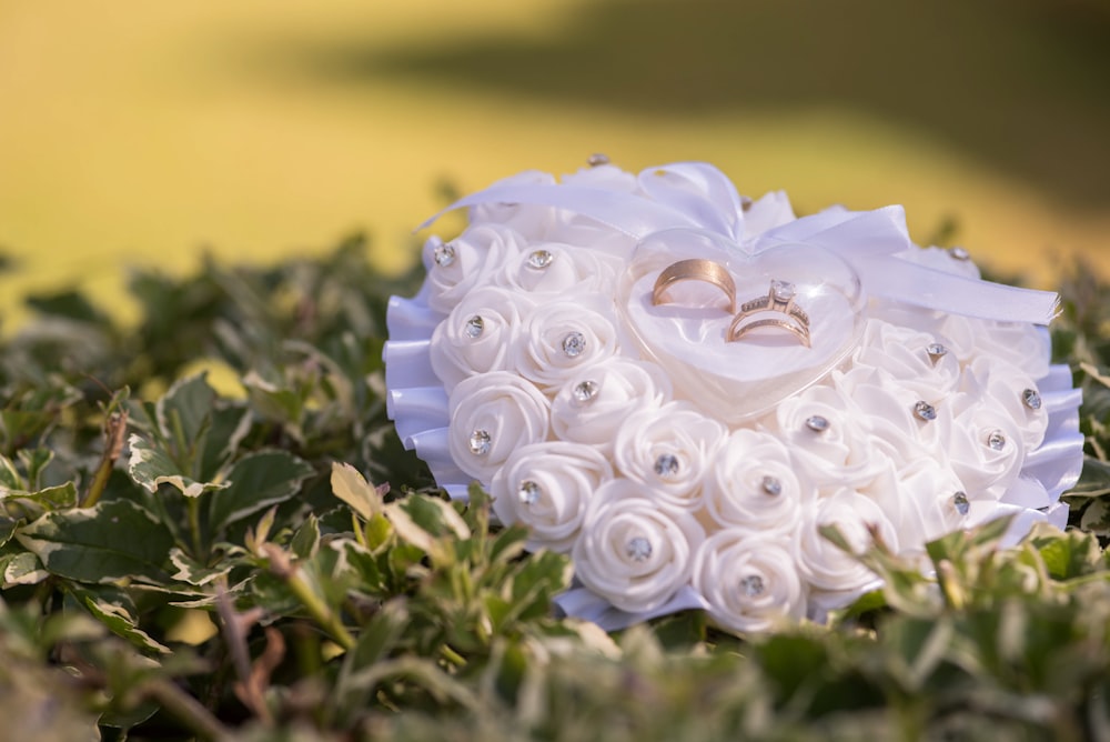 a bouquet of flowers and a wedding ring sits in the grass