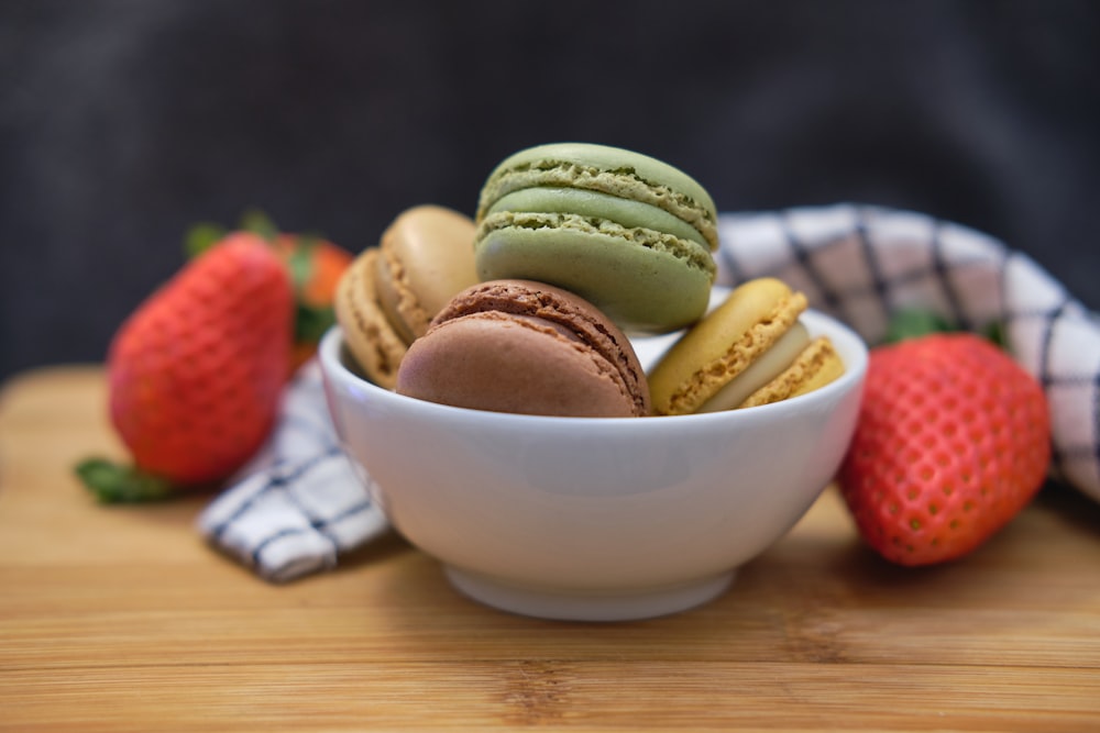a bowl of macaroons and strawberries on a table