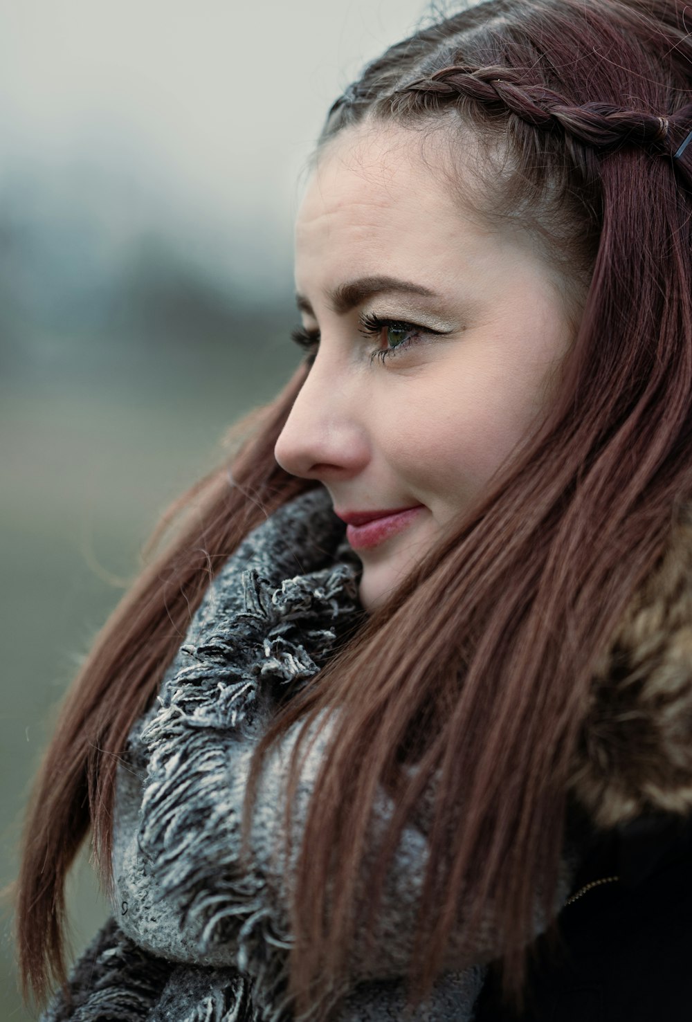 a woman with long red hair wearing a scarf