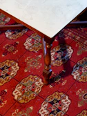 Handcrafted wooden coffee table with intricate design placed on a plush rug.