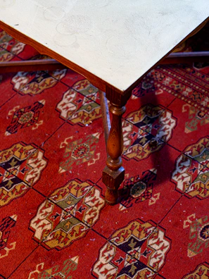 Handcrafted wooden coffee table with intricate design placed on a plush rug.