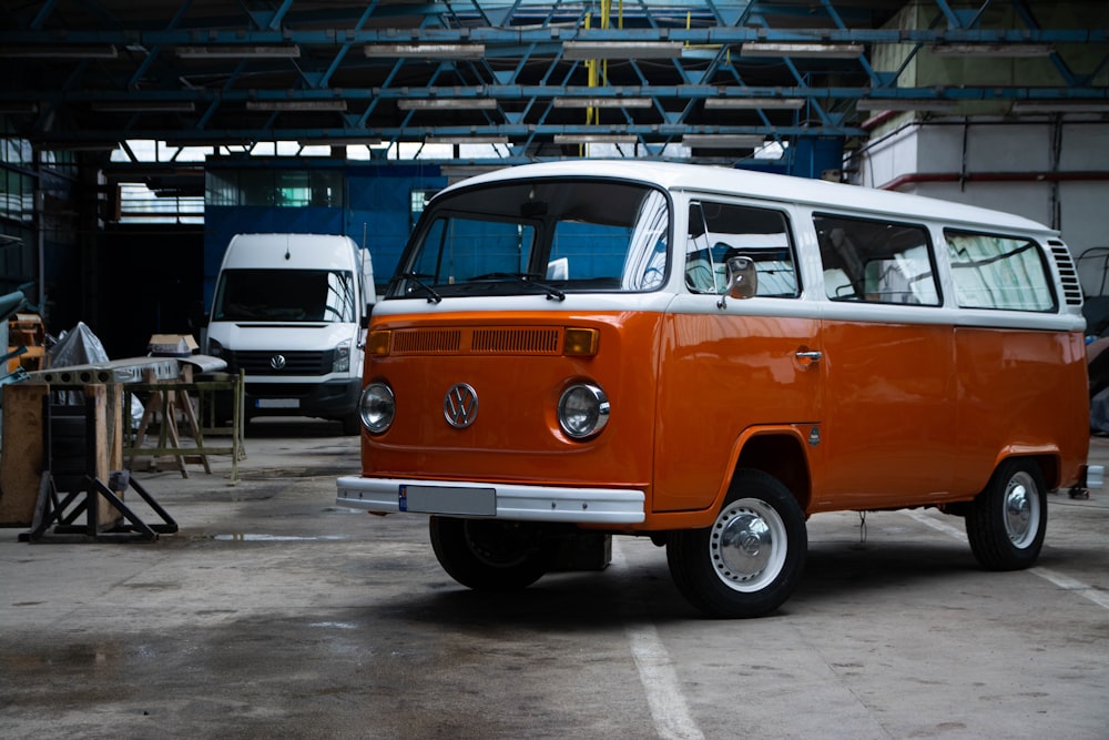 an orange and white vw bus parked in a garage