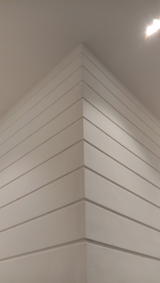 Close-up of a smooth, white Armstrong false ceiling panel installed in a modern office space.