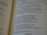A close-up of an open book with printed text, focusing on several paragraphs organized by numbers and verses. The page appears to be from a religious or spiritual book.