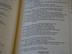 A close-up of an open book with printed text, focusing on several paragraphs organized by numbers and verses. The page appears to be from a religious or spiritual book.