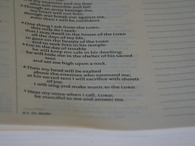 A close-up view of a page from a book, focusing on a passage that appears to be religious or spiritual text. The text is formatted in a structured, verse-like manner, with some lines in italics and numbers indicating sections or verses.